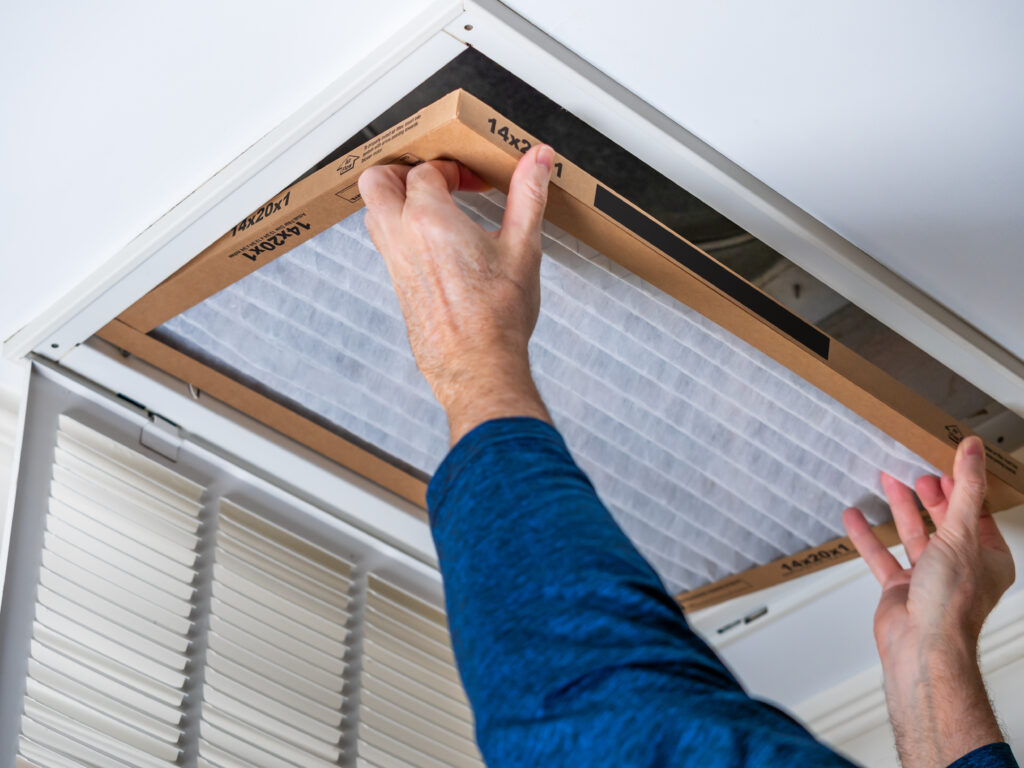 HVAC technician replacing a home air filter in Yuba City