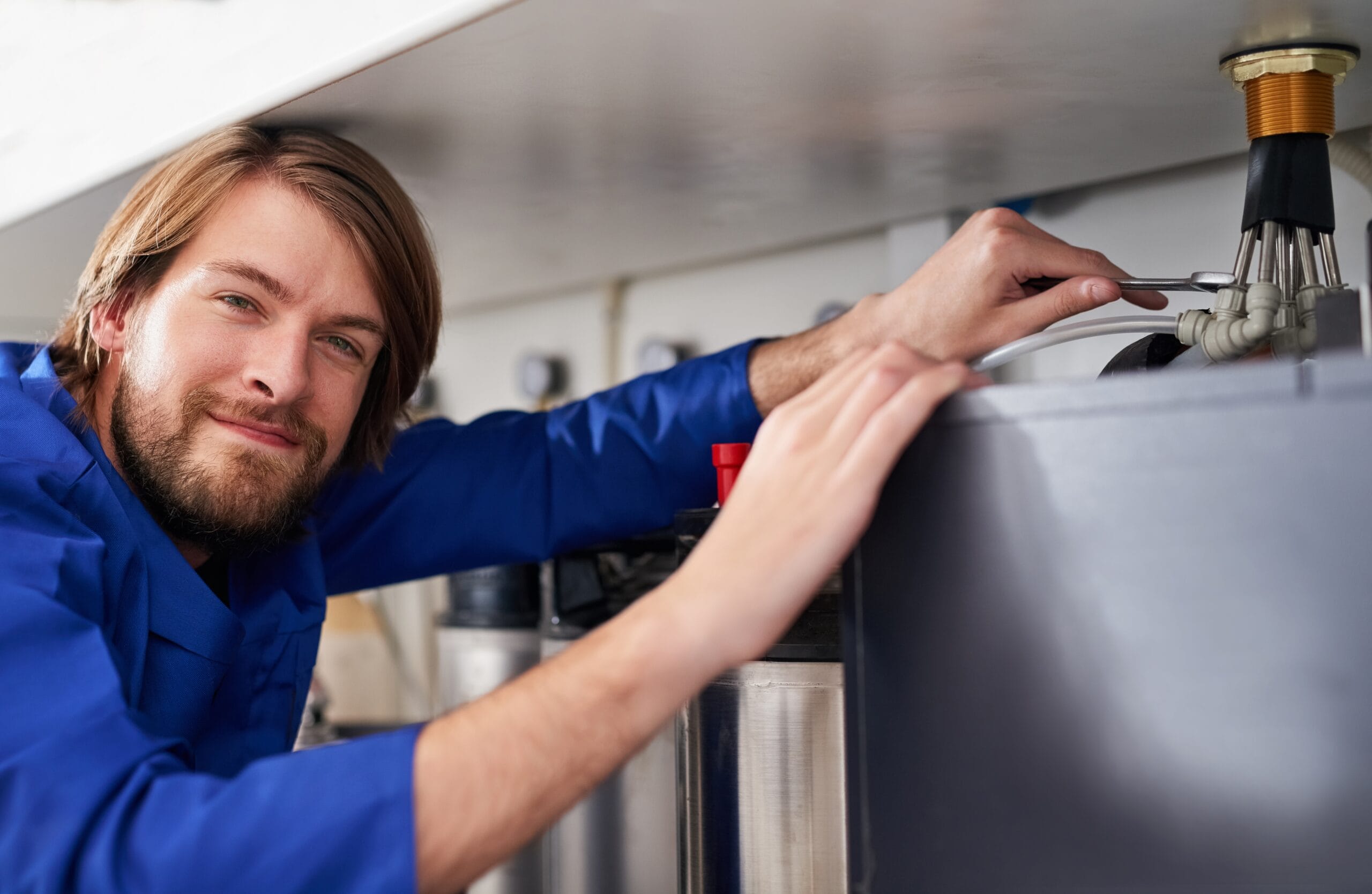 Technician servicing a residential water heater tank in Yuba City